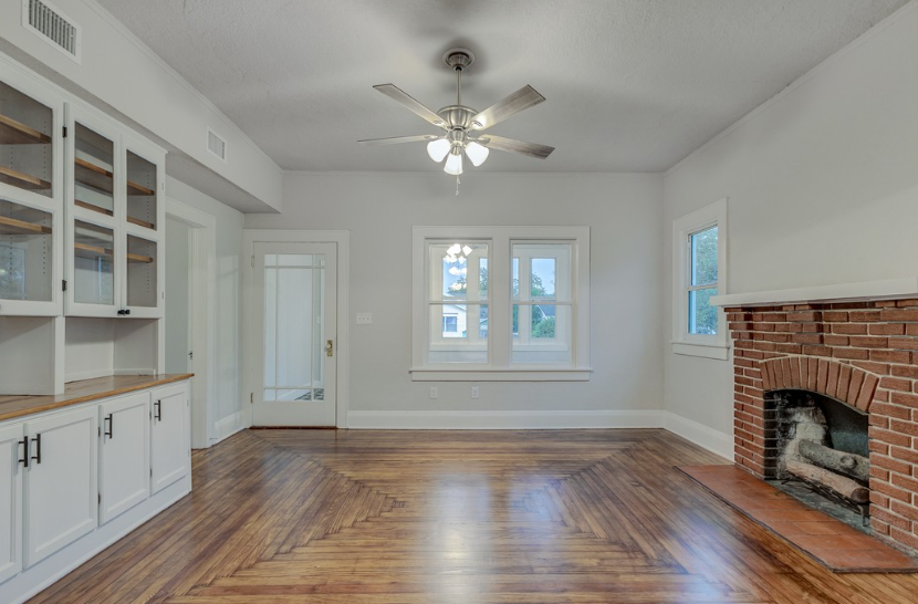The hardwood flooring in this photo is not only a basic decorative material, but also the visual focal point of the entire space. The elegant herringbone pattern runs throughout the living room, creating an elegant yet warm home atmosphere. Paired with white walls and a classic red brick fireplace, the solid wood flooring showcases its unique historical texture and craftsmanship, making it an ideal choice for those who want to combine retro style with modern comfort.