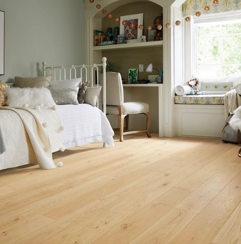 The room combines modern minimalism with a touch of French style. The hardwood floor harmonizes with the overall color scheme (off-white, light gray, and wood tones), enhancing the warm and comfortable home-like atmosphere.