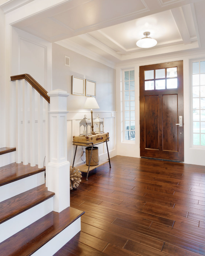 This photo perfectly illustrates the multiple advantages of solid wood flooring—from its warm, jade-like deep brown tones to its beveled edges and subtle sheen, every detail exudes the essence of high-quality living. The flooring harmoniously complements white walls, solid wood doors, and elegant furniture, creating an entryway space that balances functionality with aesthetic appeal. It is an indispensable choice for flooring in modern American or neo-classical interior design.