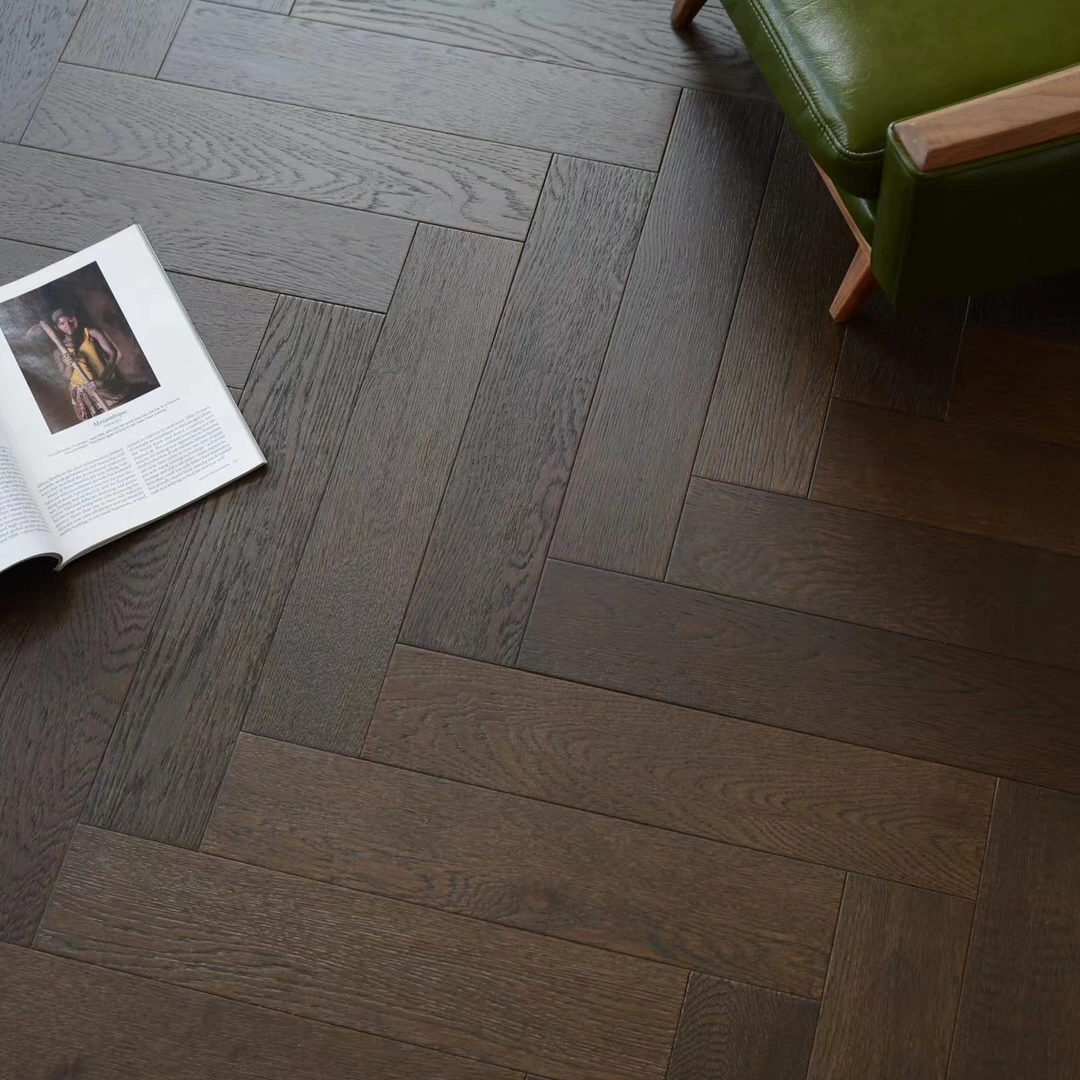 op view of premium dark smoked oak herringbone pattern parquet flooring, highlighting the rich wood grain texture and matte finish.