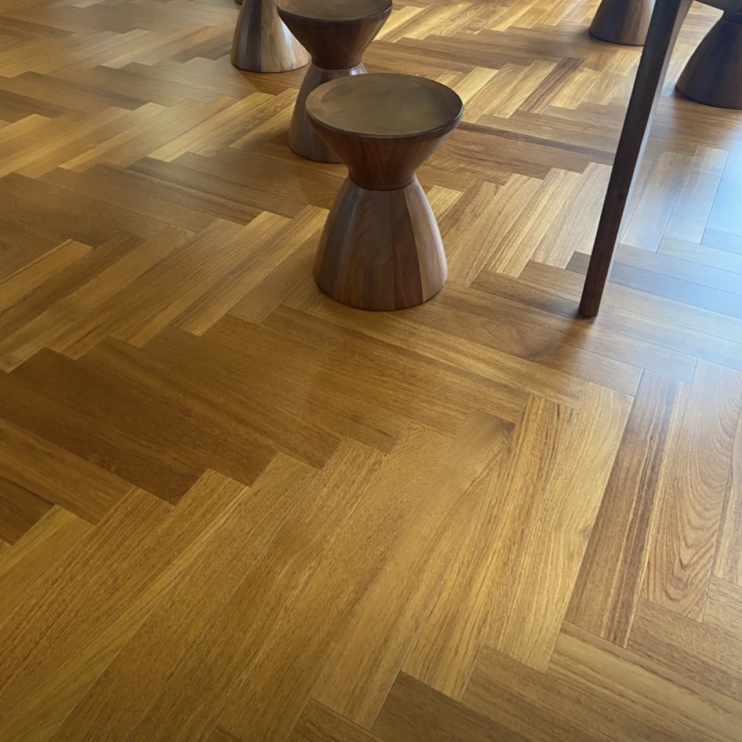 Modern interior featuring natural golden oak herringbone parquet flooring, showcasing the classic zig-zag geometric design