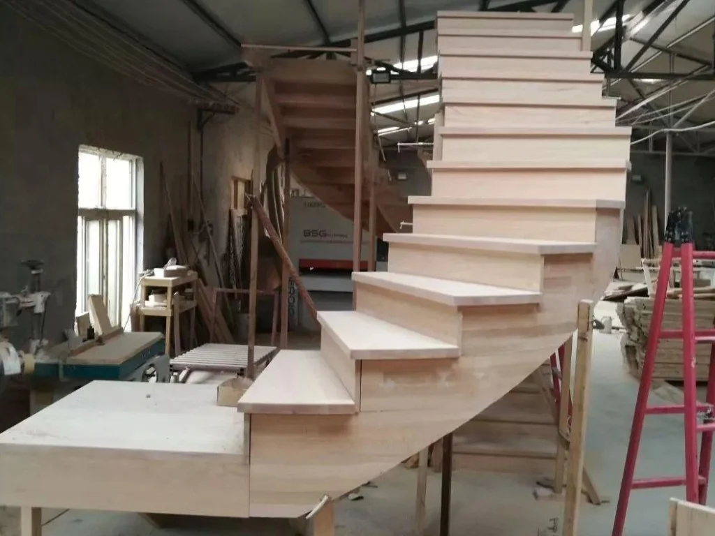 Solid hardwood stair treads and winder steps assembled in DuraMagicFloor factory workshop, showing natural wood grain before finishing